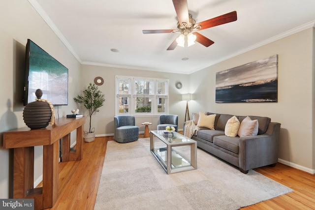 living room featuring hardwood / wood-style floors, ceiling fan, and crown molding