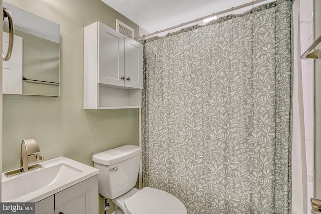 bathroom featuring a shower with shower curtain, vanity, and toilet