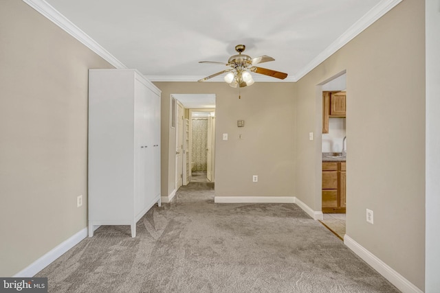 spare room featuring crown molding, ceiling fan, and light carpet