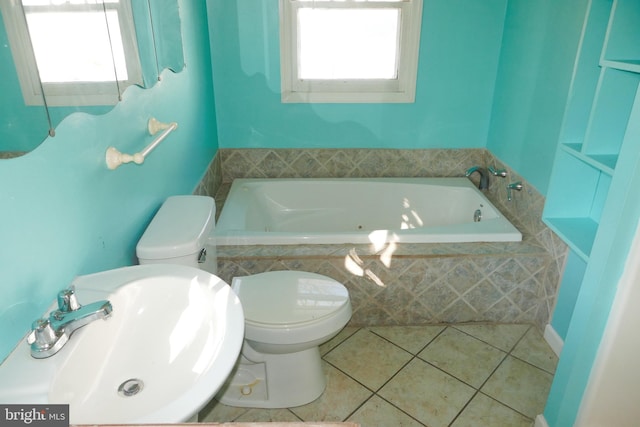 bathroom with toilet, sink, a relaxing tiled tub, and tile patterned flooring