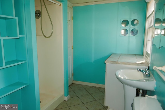 bathroom featuring tile patterned flooring, toilet, a shower, and sink