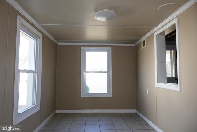 tiled spare room with plenty of natural light and ornamental molding