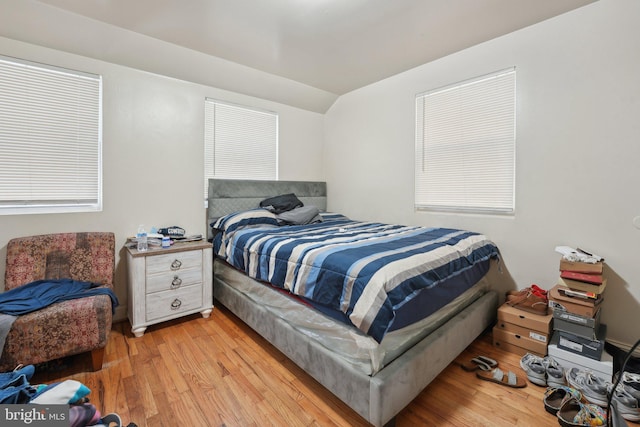 bedroom with light hardwood / wood-style flooring and lofted ceiling