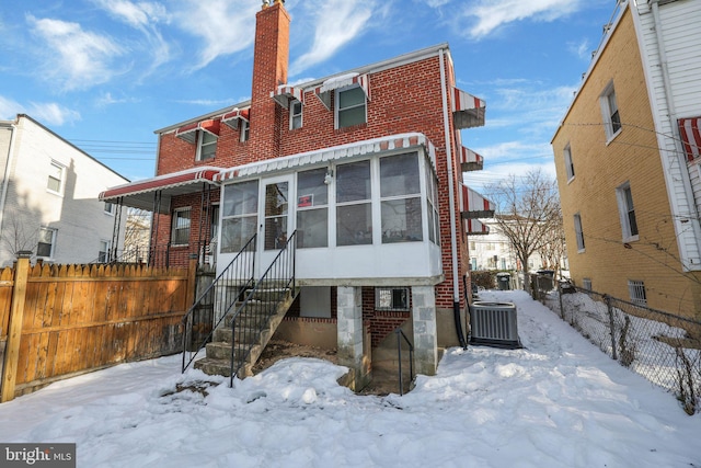 snow covered property with central AC