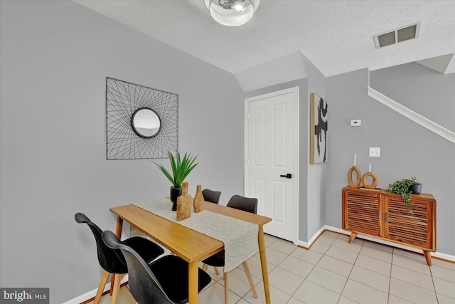 tiled dining area with a textured ceiling