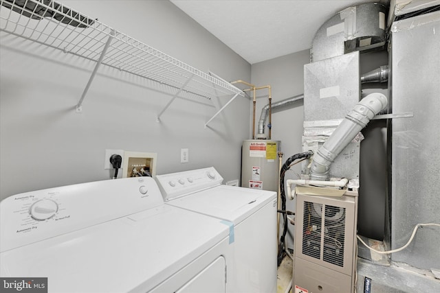 laundry area with heating unit, gas water heater, and washing machine and clothes dryer