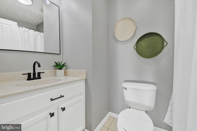 bathroom featuring tile patterned floors, vanity, and toilet