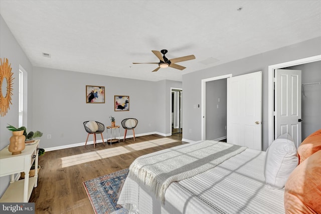 bedroom featuring dark hardwood / wood-style flooring, a closet, a spacious closet, and ceiling fan