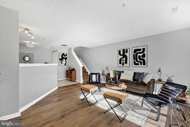 living room with a textured ceiling and hardwood / wood-style flooring