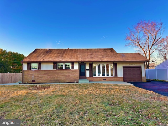 ranch-style home featuring a front lawn and a garage