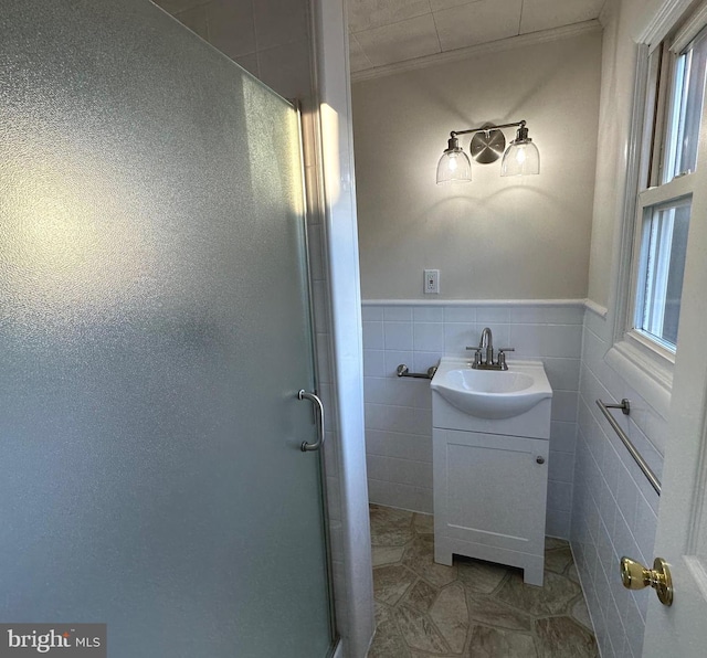 bathroom featuring tile walls, vanity, an enclosed shower, and ornamental molding