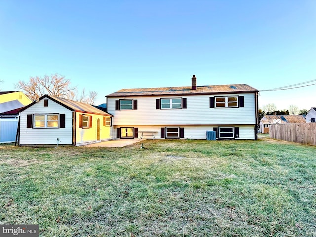 back of house featuring central air condition unit, a patio area, and a lawn