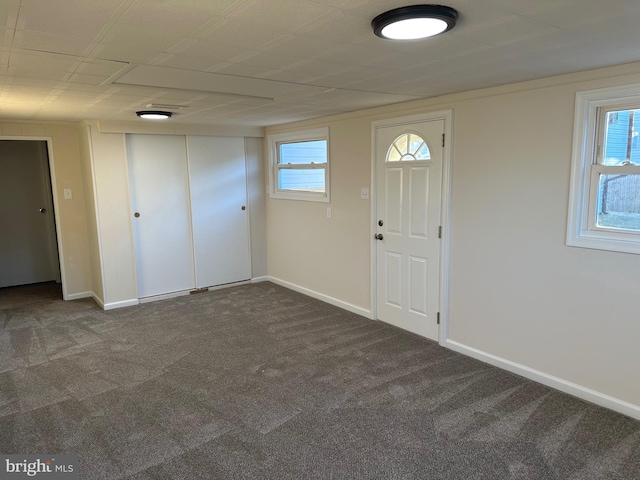 entrance foyer featuring dark colored carpet