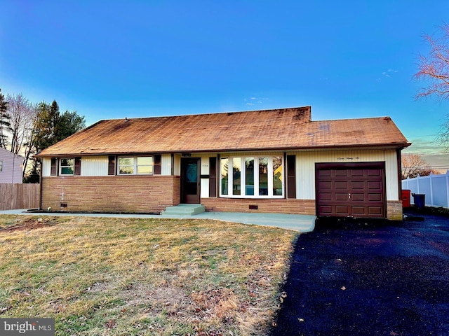 ranch-style home with a garage and a front lawn