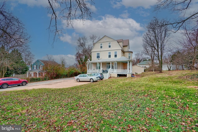 victorian house with a front lawn and a porch