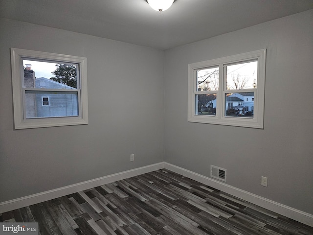 unfurnished room featuring dark wood-type flooring