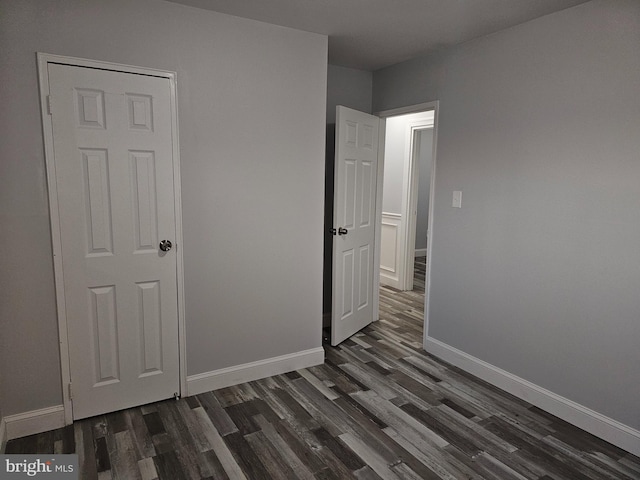 unfurnished bedroom with dark hardwood / wood-style flooring