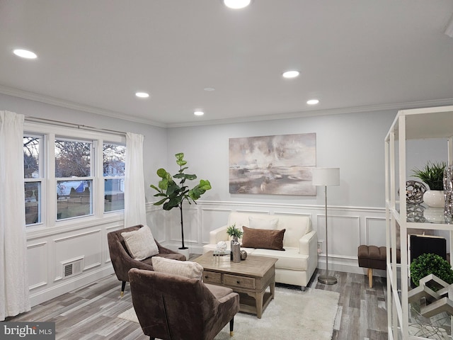 living room with light hardwood / wood-style floors and ornamental molding