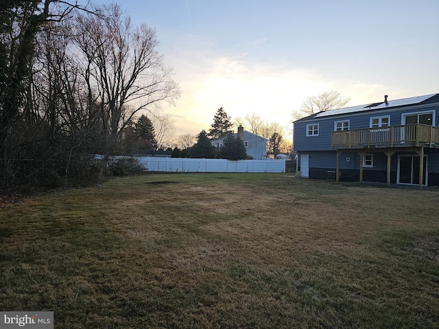 yard at dusk featuring a deck