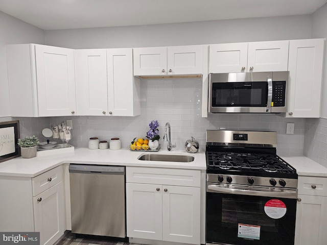 kitchen featuring white cabinets, decorative backsplash, sink, and stainless steel appliances