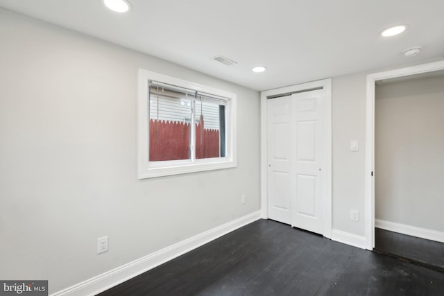 unfurnished bedroom with a closet and dark hardwood / wood-style floors