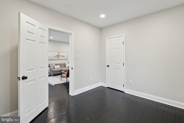 unfurnished room with dark hardwood / wood-style flooring