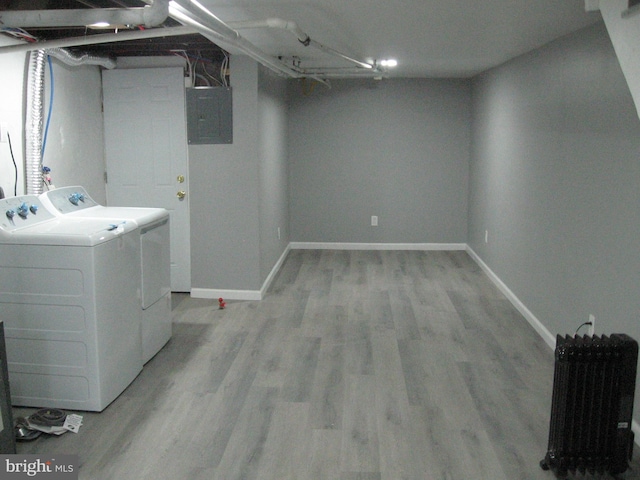 washroom featuring separate washer and dryer, electric panel, and light hardwood / wood-style flooring