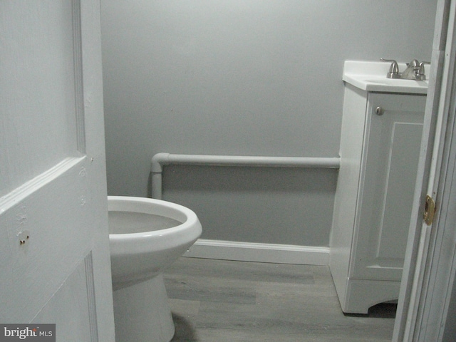 bathroom featuring vanity, hardwood / wood-style flooring, and toilet