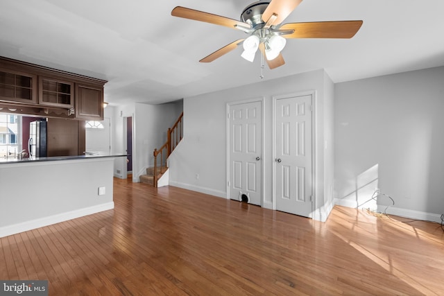 unfurnished living room featuring ceiling fan and dark hardwood / wood-style floors