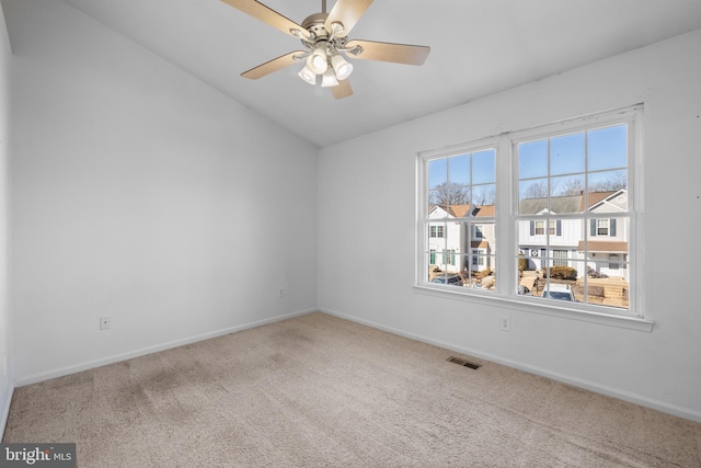 carpeted empty room featuring vaulted ceiling and ceiling fan