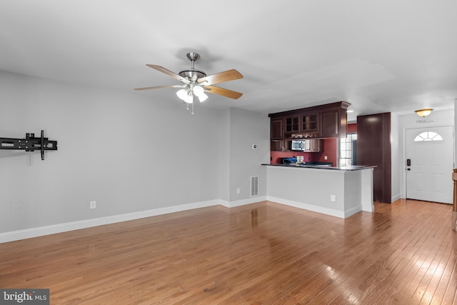 unfurnished living room with ceiling fan and hardwood / wood-style floors