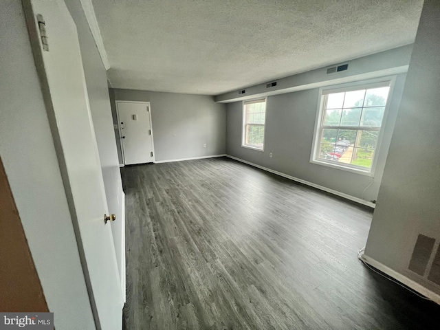 spare room with wood-type flooring and a textured ceiling