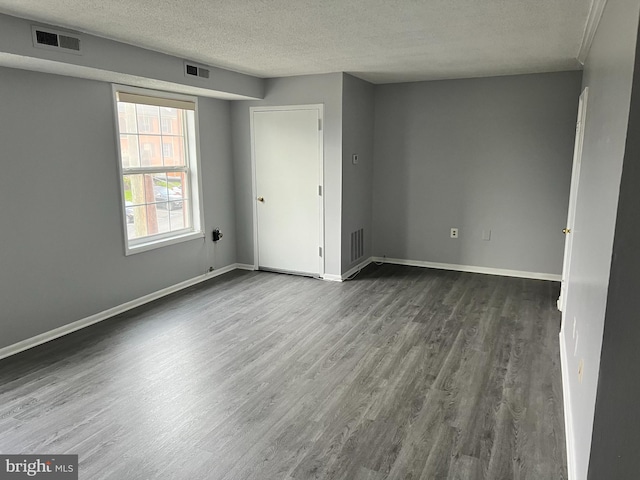 empty room featuring dark hardwood / wood-style floors and a textured ceiling