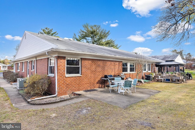 back of house with a gazebo, a patio, central AC unit, and a lawn