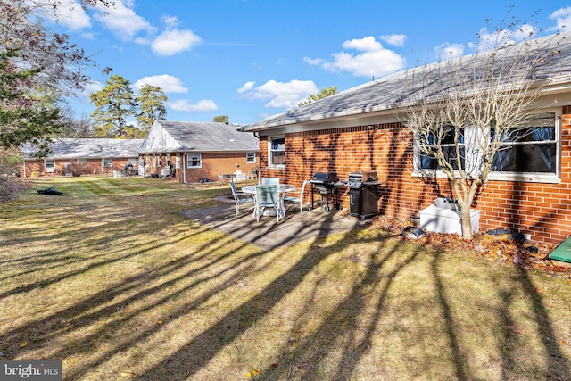 rear view of property featuring a patio area and a lawn