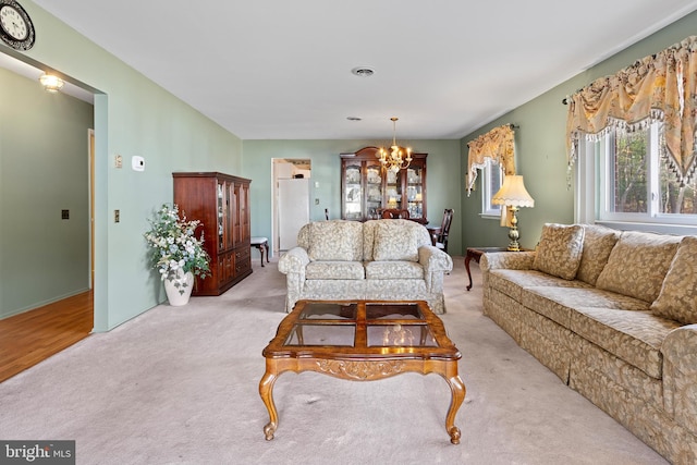 living room featuring a chandelier and light carpet