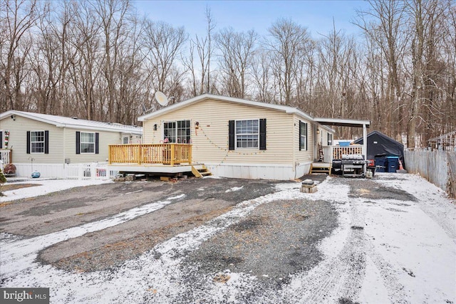 manufactured / mobile home featuring a carport and a deck