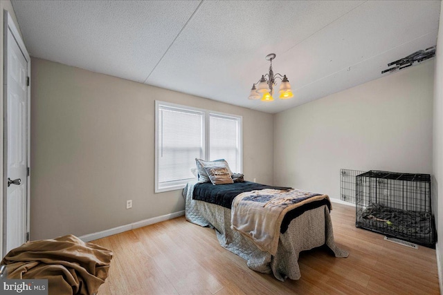 2612 Oakwood Ct, East Stroudsburg, PA 18302 - bedroom featuring a chandelier, a textured ceiling, and light hardwood / wood-style floors