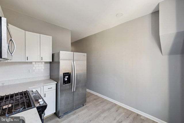 kitchen with white cabinetry, tasteful backsplash, stainless steel fridge with ice dispenser, stove, and light wood-type flooring