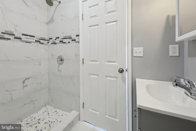 bathroom with vanity and tiled shower