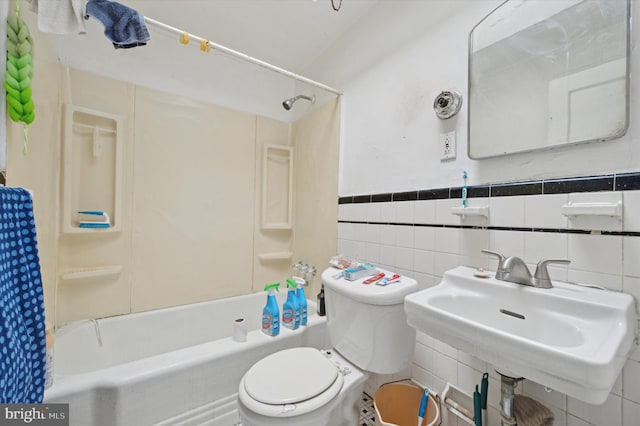 full bathroom featuring bathing tub / shower combination, sink, tile walls, and toilet