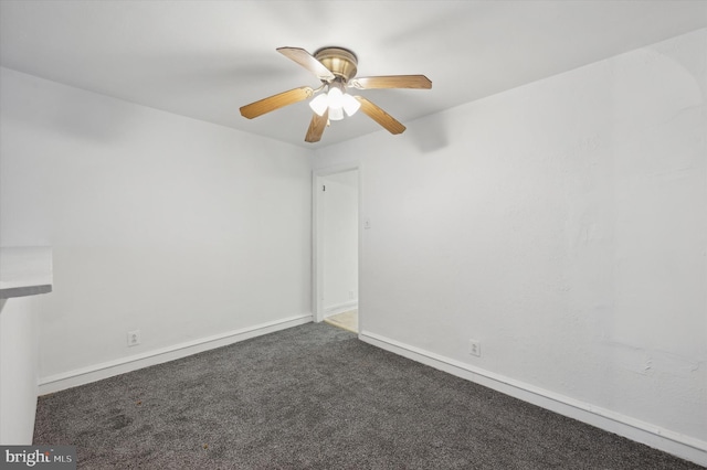 empty room with dark carpet and ceiling fan