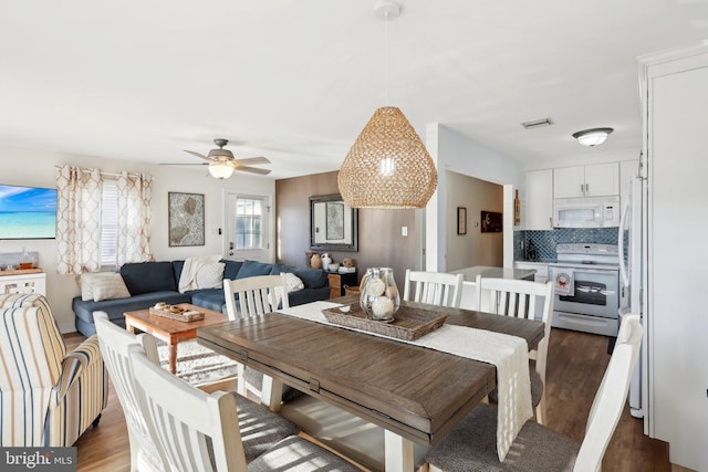 dining space with ceiling fan and dark hardwood / wood-style flooring