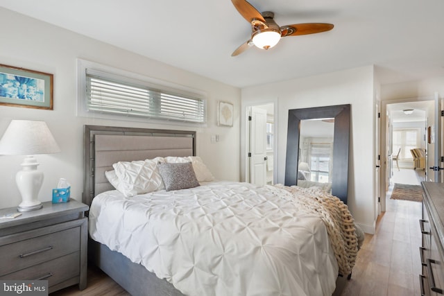 bedroom with ceiling fan, light hardwood / wood-style floors, and multiple windows