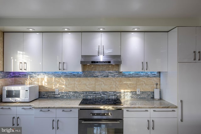 kitchen featuring white cabinets, backsplash, black gas stovetop, and stainless steel oven