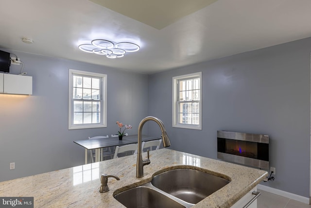 kitchen featuring light stone countertops, sink, and light tile patterned floors