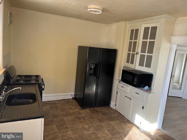 kitchen with white cabinets, sink, and black appliances