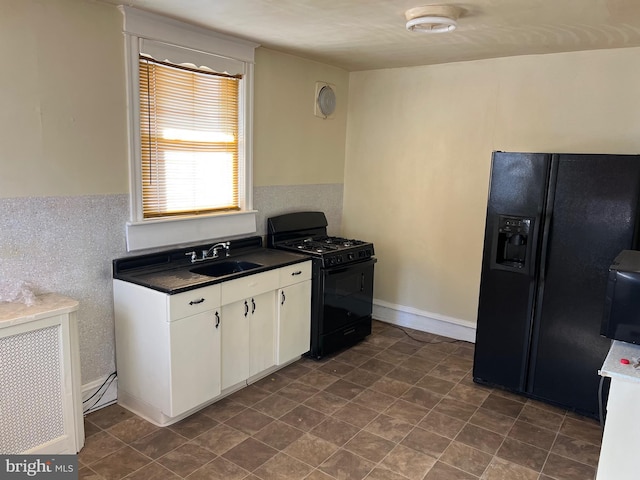 kitchen with white cabinetry, sink, and black appliances