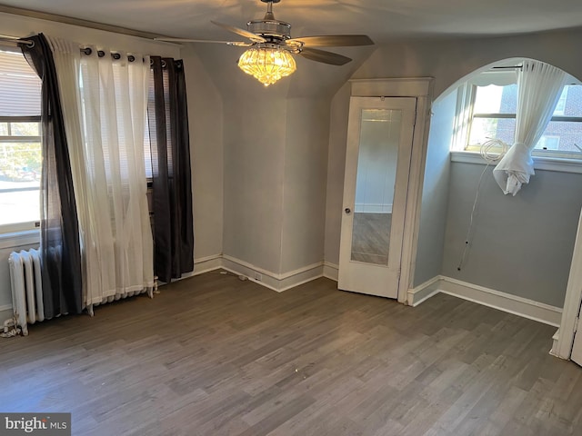 unfurnished room featuring ceiling fan, wood-type flooring, and radiator