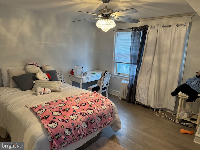 bedroom with ceiling fan, dark hardwood / wood-style floors, and radiator